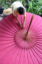 An Asian woman making a parasol 