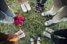 shoes of a diverse group of people in a circle.