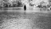 woman walking through a river 