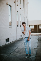 a young man standing in an alley posing 