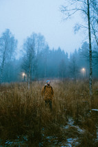 man walking down hill in a foggy forest 