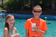 smiling children enjoying a summer day poolside with snow cones 