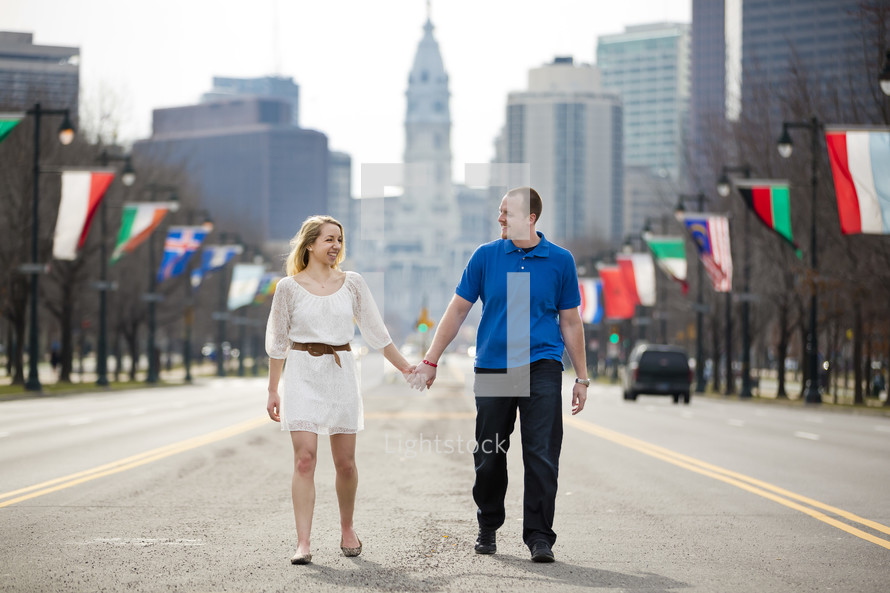 couple walking holding hands and various flags 