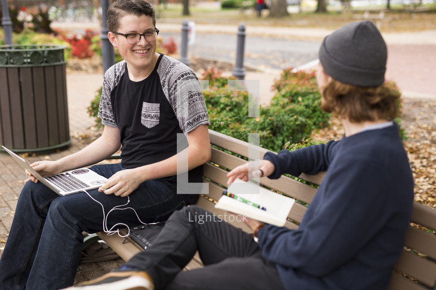 college students sitting on benches studying 