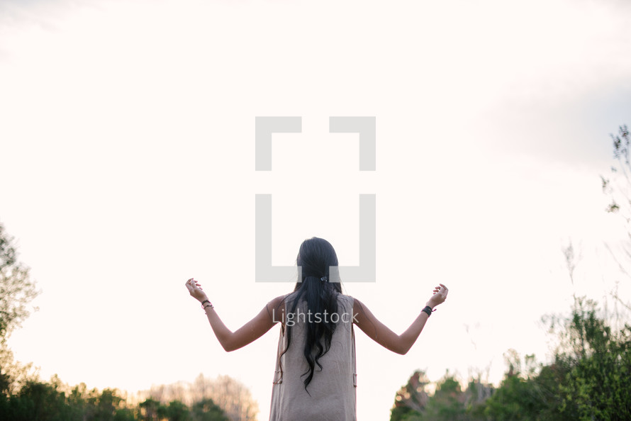 young woman with raised hands 