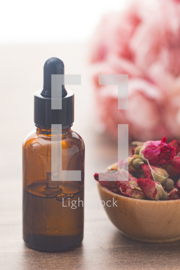 dried roses and essential oil bottle 