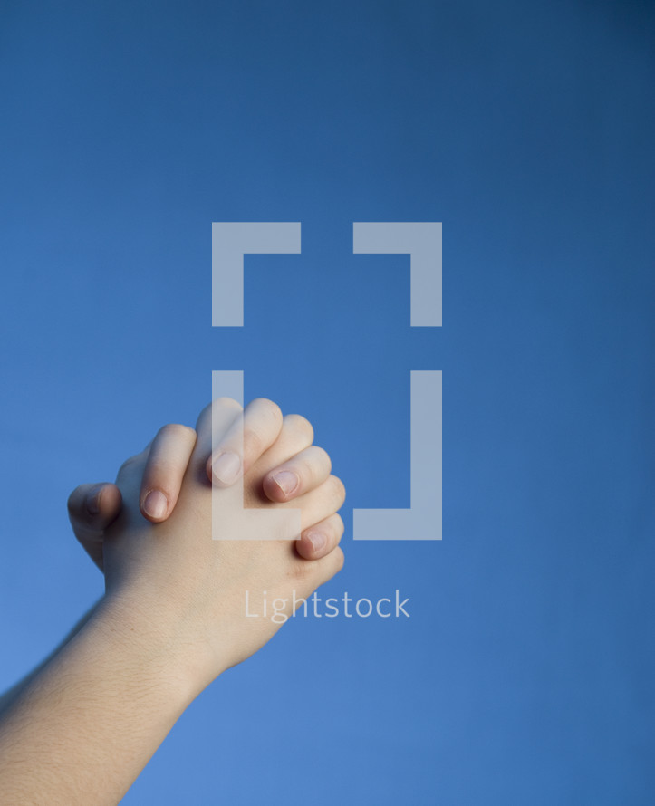 praying hands against a blue background 