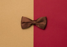 brown bowtie on tan and red background 