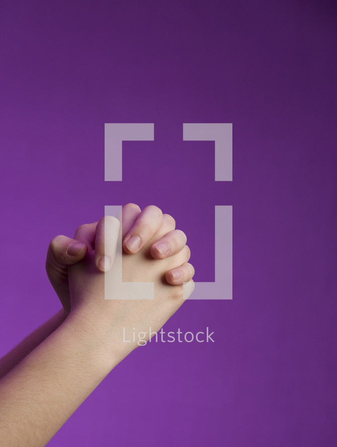 praying hands against a purple background 