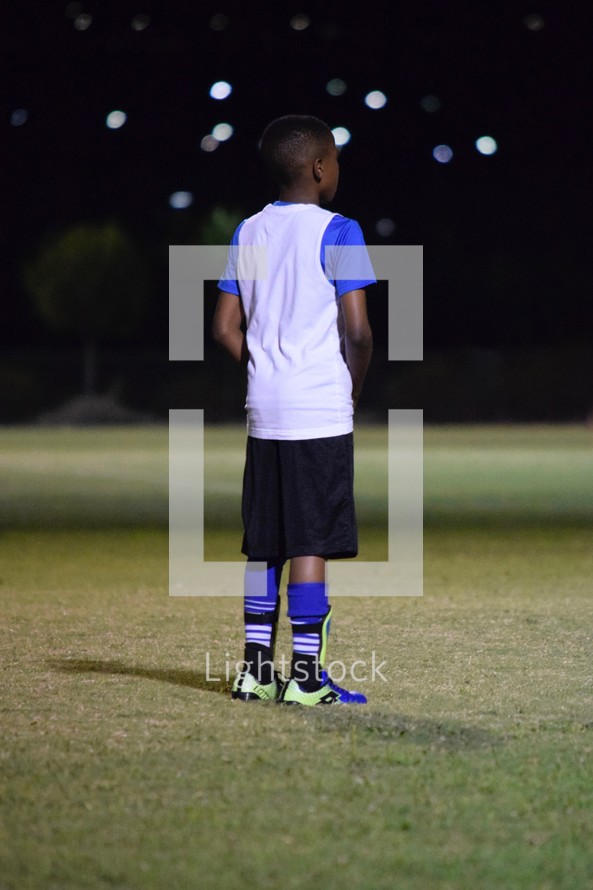 a young man standing on a soccer field ready to play 