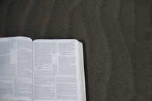 open Bible in sand 