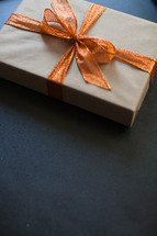 a wrapped gift with an orange bow 