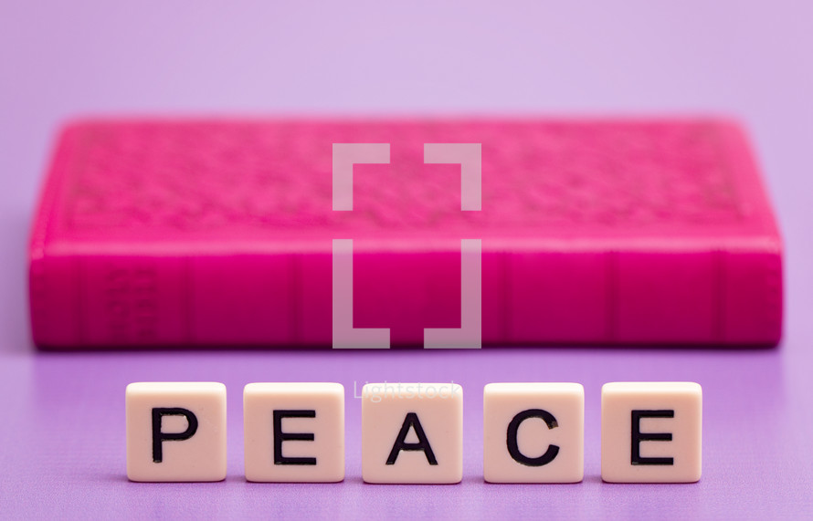 word peace beside a pink Bible 