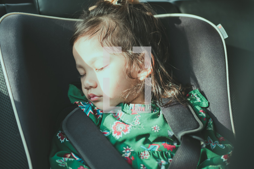 a child sleeping in a car seat 