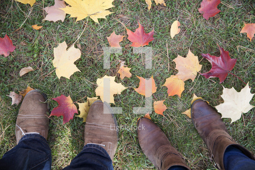 boots standing in grass and fall leaves 