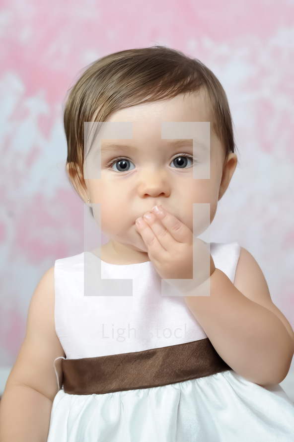 Infant girl blowing kisses.