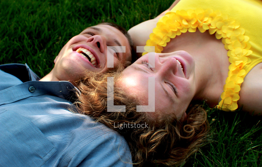 young couple lying in the grass 