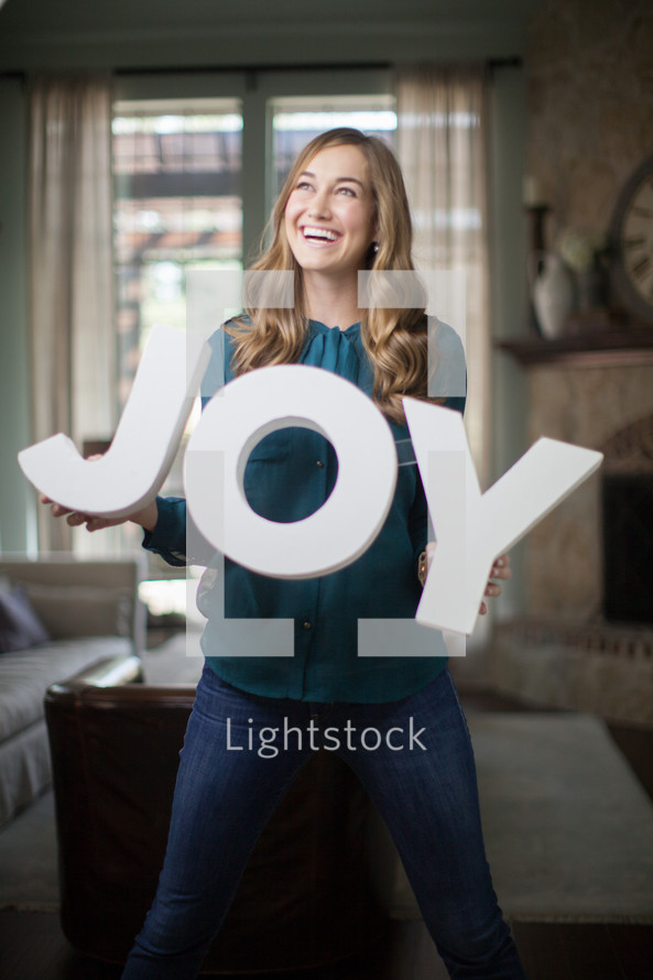 a woman holding a sign of the word joy