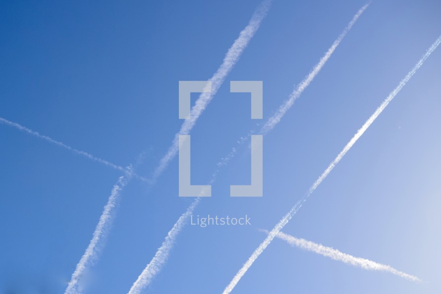 many plane contrails in the sky