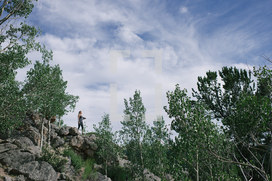woman standing on rocks on a mountainside 