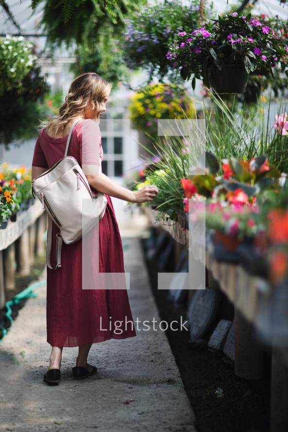 a young woman walking through a garden center 