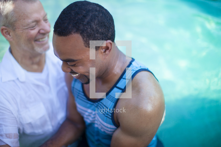 Man baptizing a man in a pool of water.