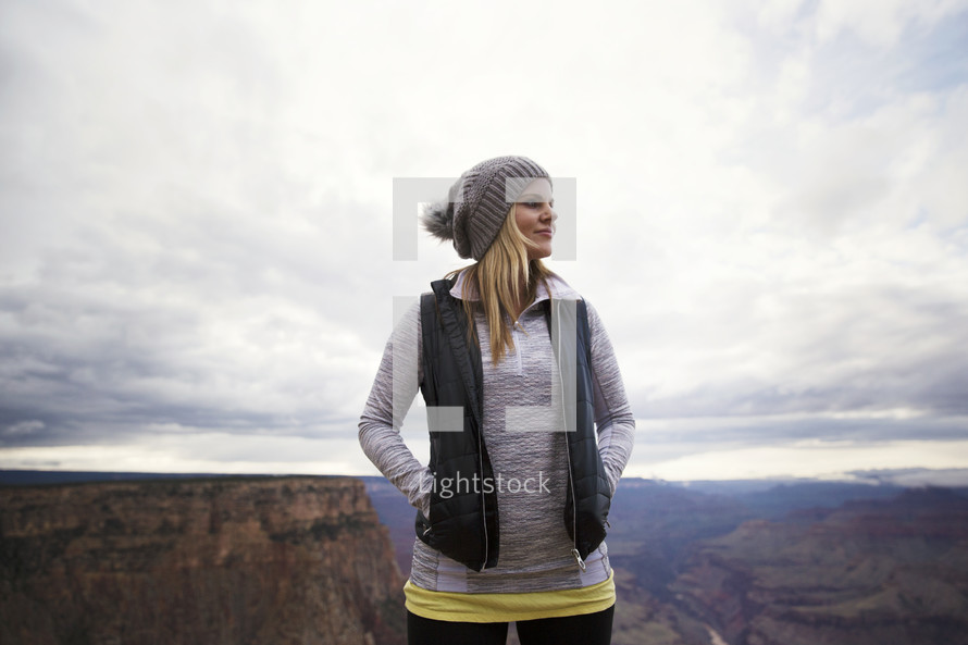 woman standing at the top of a mountain 