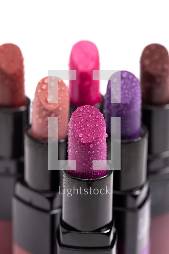 Multiple Tubes of Different Colored Lipsticks Isolated on a White Background