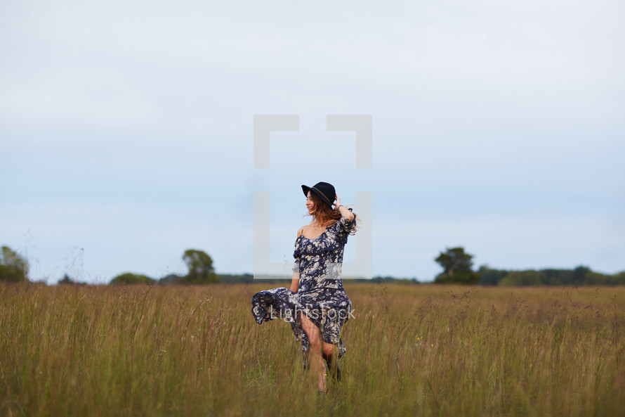 woman walking through a field 