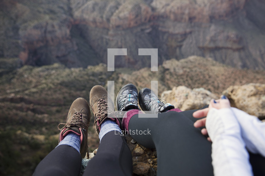 feet hanging off the side of a cliff