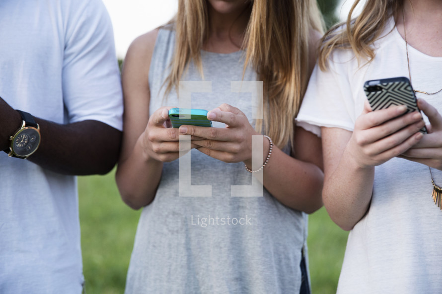 row of young adults on cellphones 