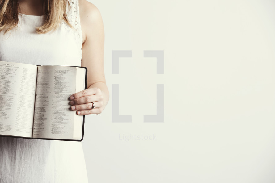 Woman holding an open Bible.
