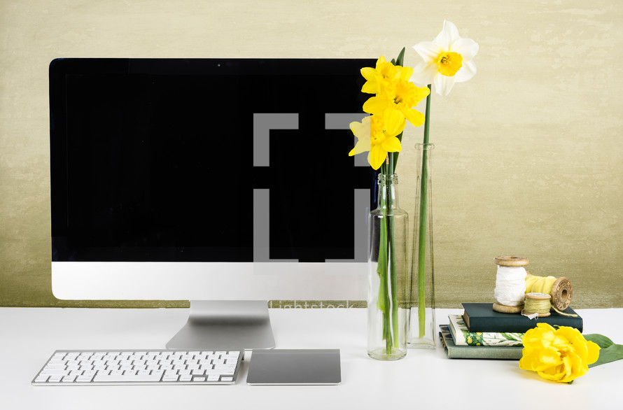 daffodils in a vase and computer 