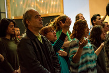 congregation with raised hands during a worship service 