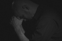 a man with head bowed in prayer 