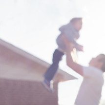 blurry image of a father lifting up his son 