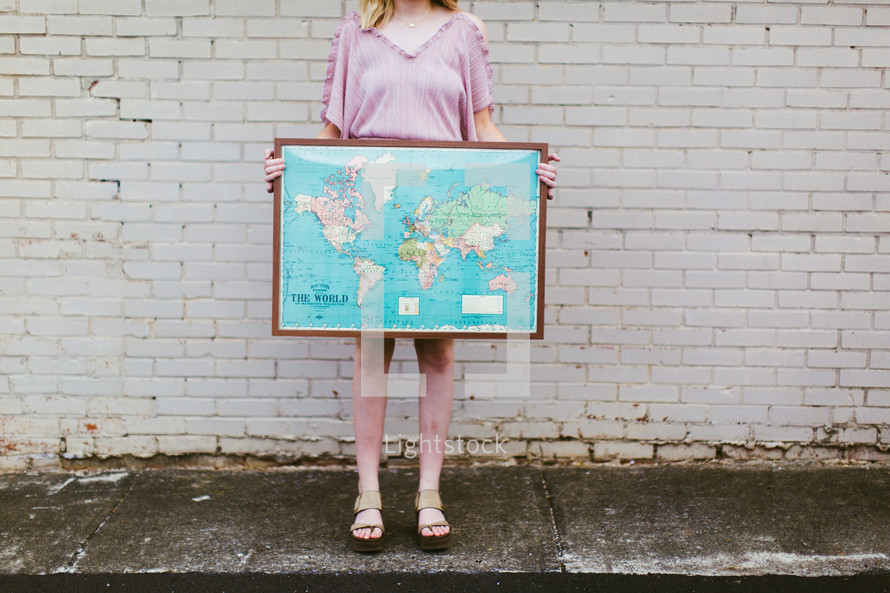 young woman holding a framed map 