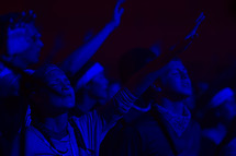 teens with raised hands at a worship service 