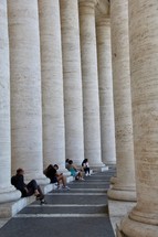 people resting between columns in Rome 