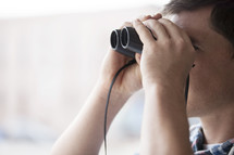 man looking through binoculars 