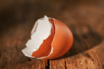 Abstract egg shell cracked in two parts on a wooden table