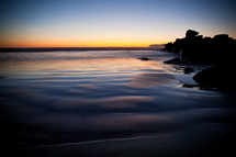 tide washing onto a shore at dusk 