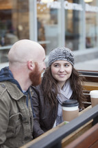 Couple sitting outside with coffee.