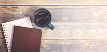 Bible, journal, and coffee mug on a wood background 