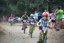 children riding bikes on a dirt bike track during competition 
