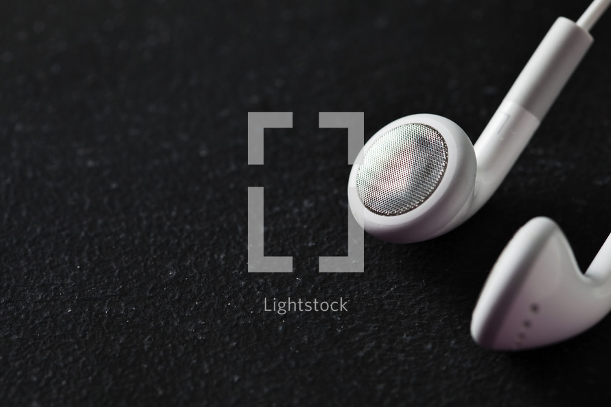 White ear buds on black table. 