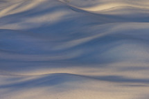 Abstract background of a snowdrift waves in sunset light