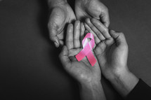 holding a pink ribbon 
