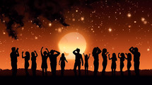 Silhouette of people dancing on the beach at sunset at night in Summer. AI Generated