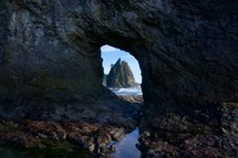 view of a rock formation in the water through a cave 
